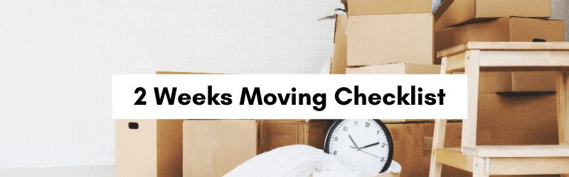 A stack of moving boxes and a clock on a table, with a banner reading "2 Weeks Moving Checklist.