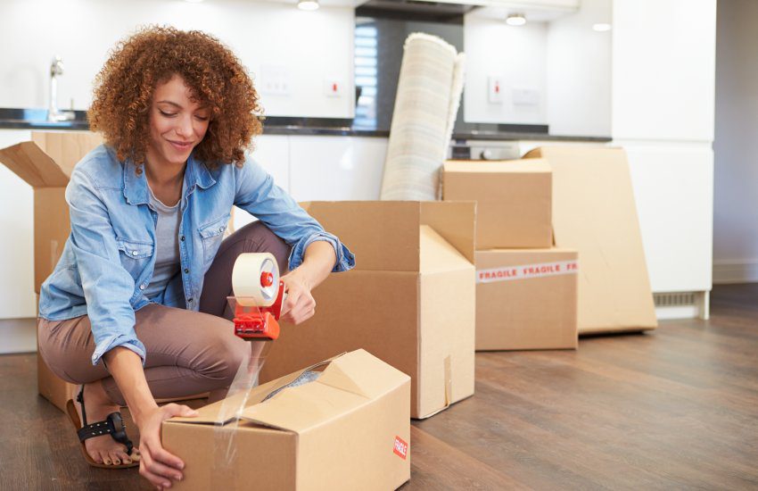 Woman Sealing Boxes Ready For House Move