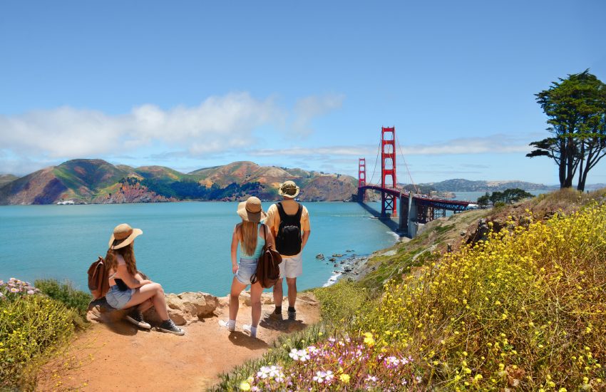 Family looking at beautiful summer mountains landscape, on hiking trip. Golden Gate Bridge, over Pacific Ocean, mountains in the background. San Francisco, California, USA