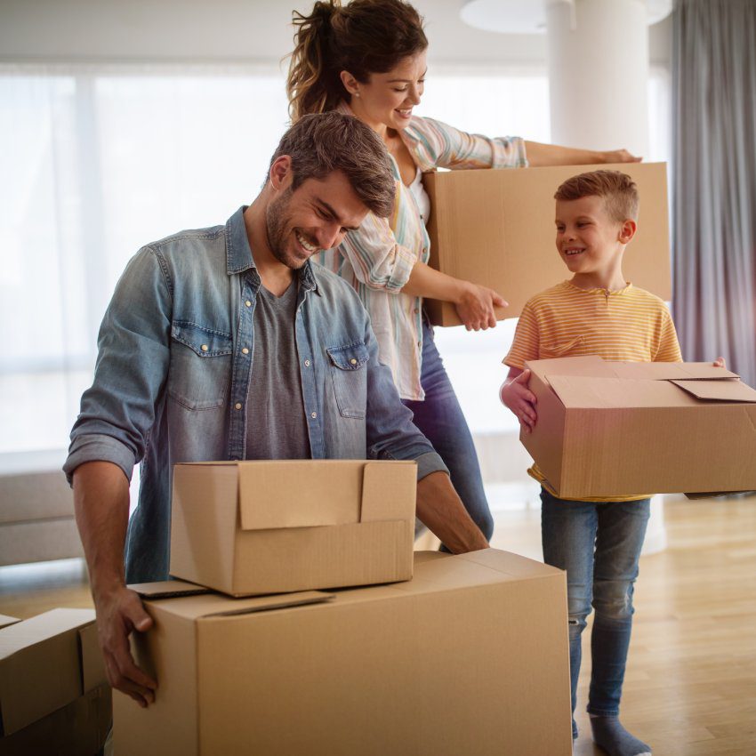 Happy family unpacking boxes in new home on moving day