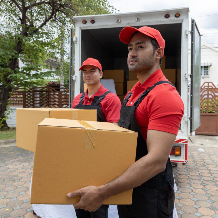 Portrait of two movers unloading boxes.