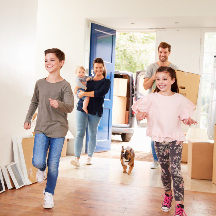 Family Carrying Boxes Into New Home