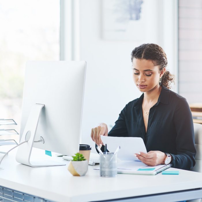 Business, computer and woman with documents in office for savings, budget or investment planning and research. Financial, review and girl auditor with company tax admin for profit check and analysis