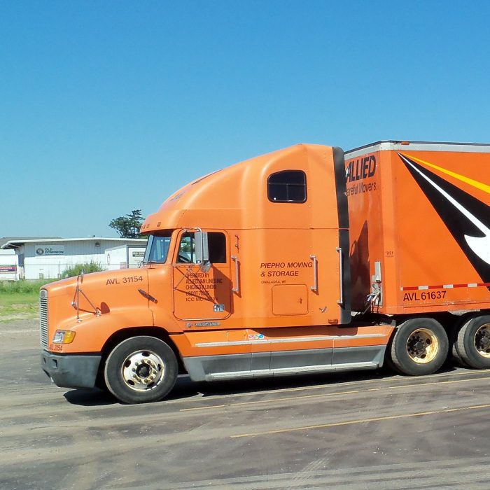 Atlas Allied orange semi truck parked in a lot