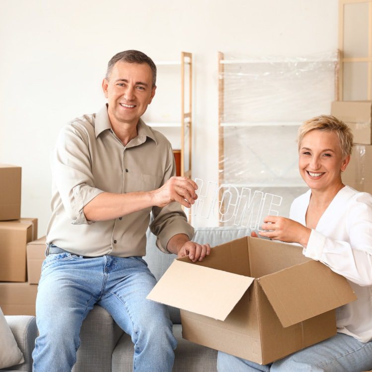 Mature couple packing things in room on moving day