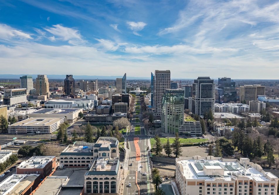 An aerial image of the Tower Bridge and State Capitol Building in Sacramento, California on a beautiful day after a rain storm that filled the Sacramento River