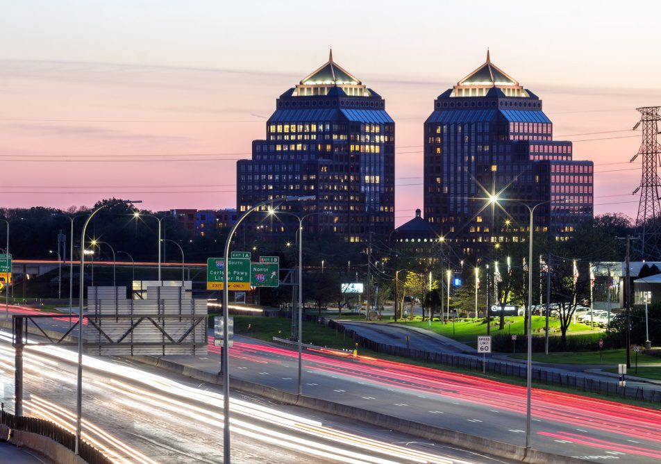 MINNETONKA, MN - SPRING 2022 - A Telephoto Shot of the Twin Carlson Center Buildings in Suburban Minnesota and Long Exposure Traffic Trails during a Spring Twilight