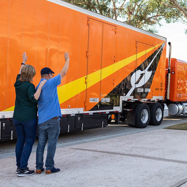 couple senior waving goodbye salute to Atlas Piepho Moving truck