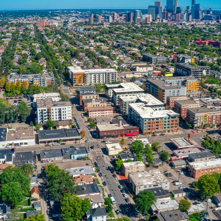 Aerial view of downtown Denver, Colorado, showcasing the city skyline and surrounding mountains on a clear day.