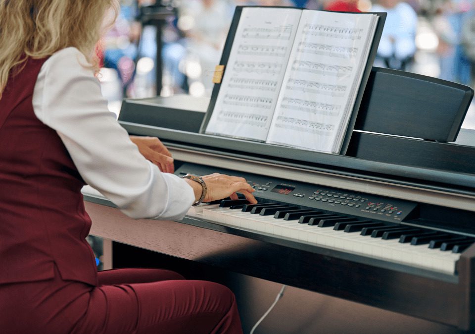 A woman playing the piano, showcasing her skill and passion for music in a bright, inviting room. Piano mover in Minneapolis.