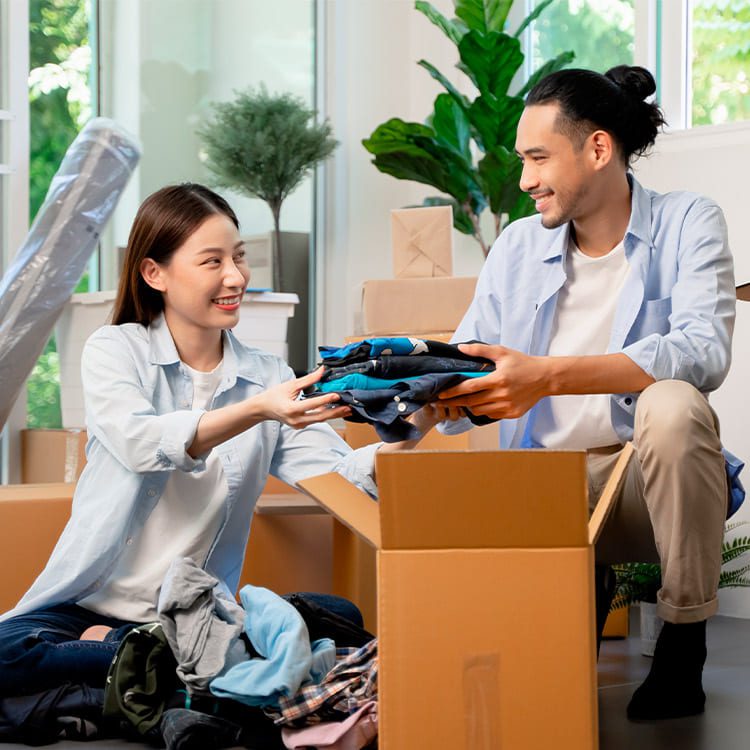 A young couple is seen moving boxes into their new home, representing their transition from St. Paul to Denver.