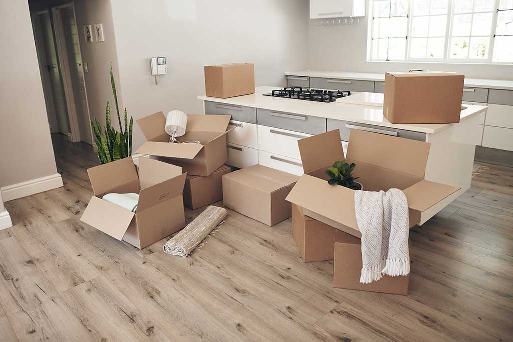 Moving boxes stacked in a kitchen, illustrating the process of relocating from St. Paul to Austin.