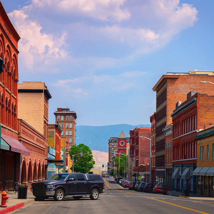 A truck drives down a city street, symbolizing a journey from Minnesota to Montana.