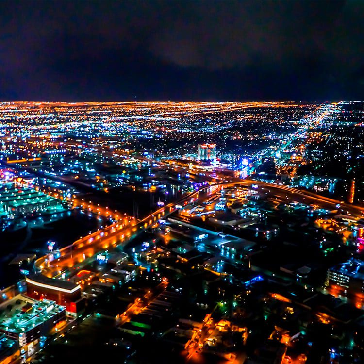 Nighttime aerial view of Las Vegas city lights, highlighting the bustling streets and skyline