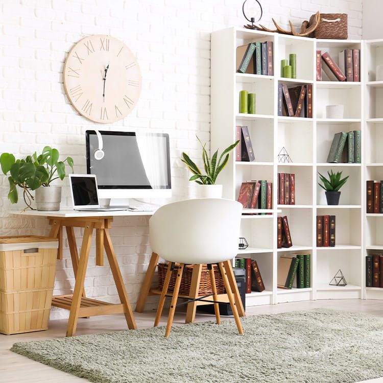 A white desk and chair next to a bookcase, representing a home office environment in a moving guide.