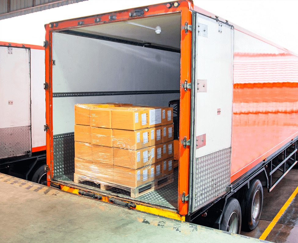A partially open truck trailer reveals stacked boxes on a pallet inside, ready for unloading.