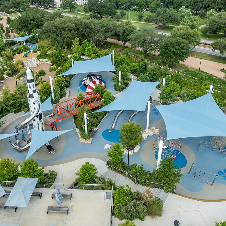  A lively park scene with a playground, water slide, and multiple activity areas for outdoor fun and enjoyment.
