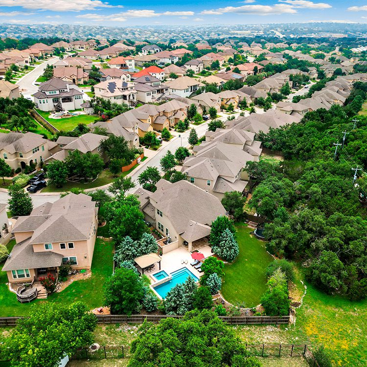 Overhead perspective of a residential area featuring various homes, streets, and greenery in a neighborhood setting.