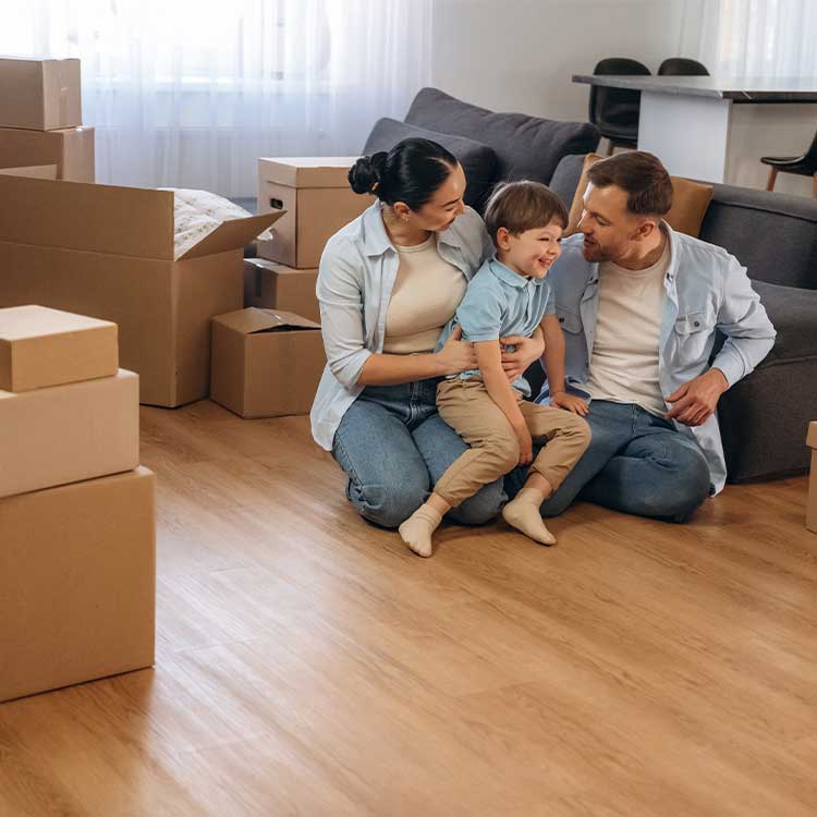 in a living room filled with boxes, a family sits on the floor, getting ready for their move from Minneapolis to Miami.