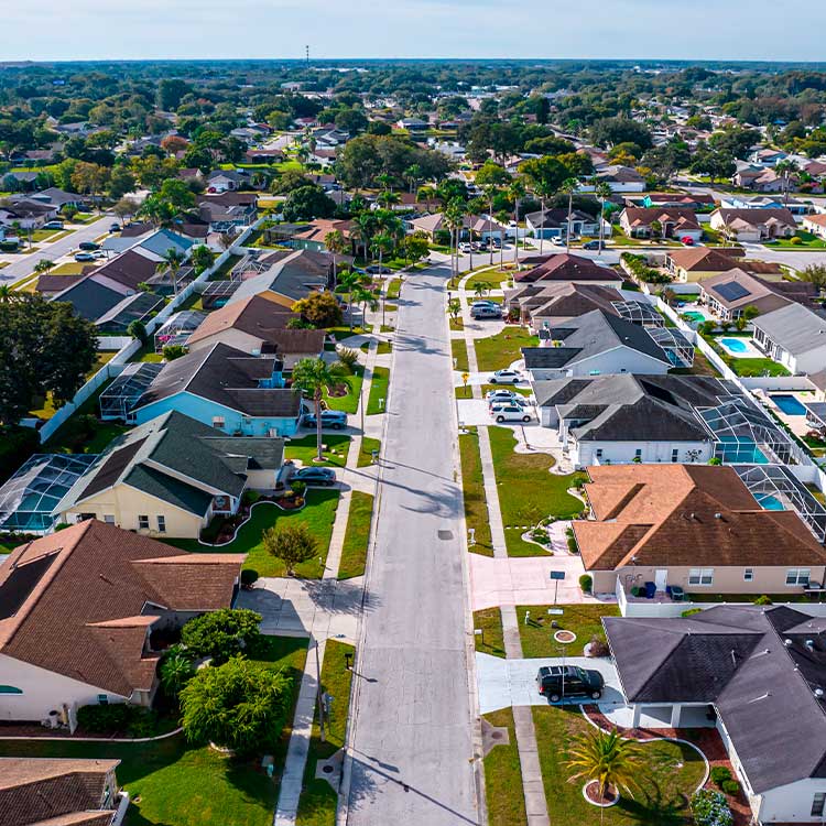 Aerial perspective of a residential suburb, featuring houses and trees, symbolizing a transition from Minneapolis to Miami.