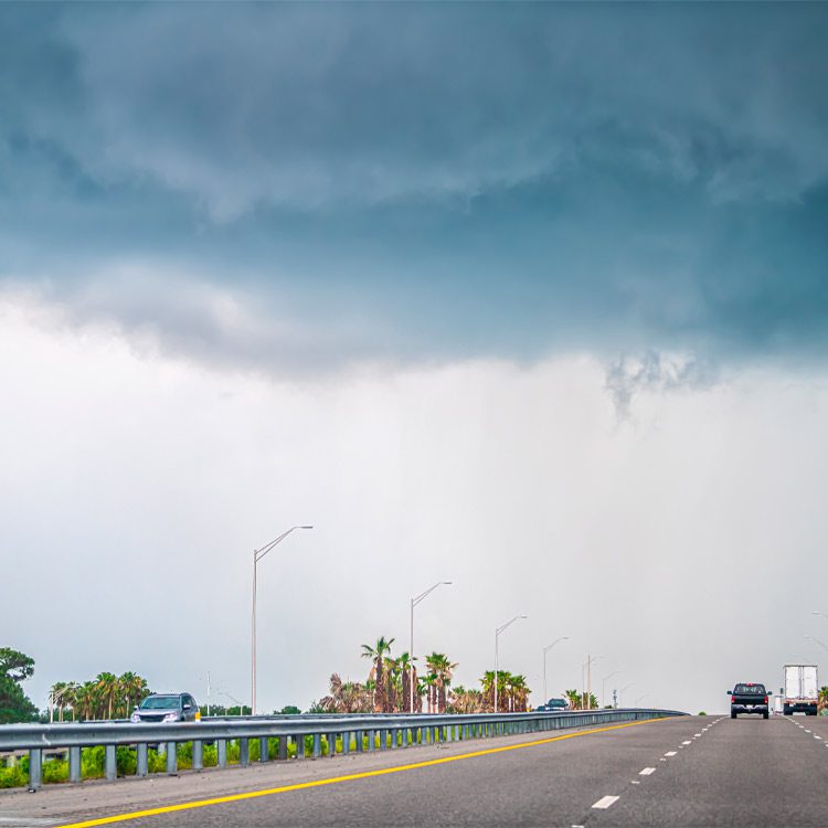 Interstate highway road 95 i95 near Daytona Beach, Florida with cars traffic by storm stormy gray blue clouds cloudy cloud cover