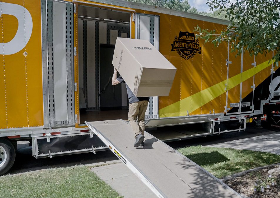 Mover downloading boxes from moving truck